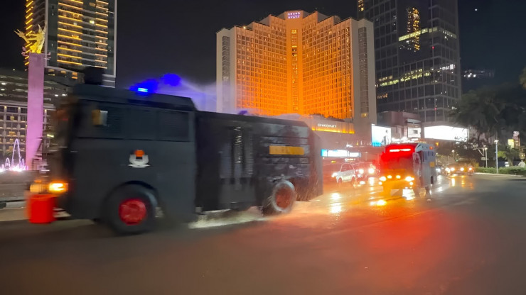 Brimob Polda Metro Jaya Semprot Jalan dan Bagikan Masker Antisipasi Abu Vulkanik Anak Krakatau