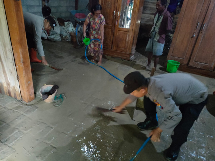 Kompak, Polisi Bersama Warga Bersihkan Sisa Lumpur Akibat Banjir di Ngawi